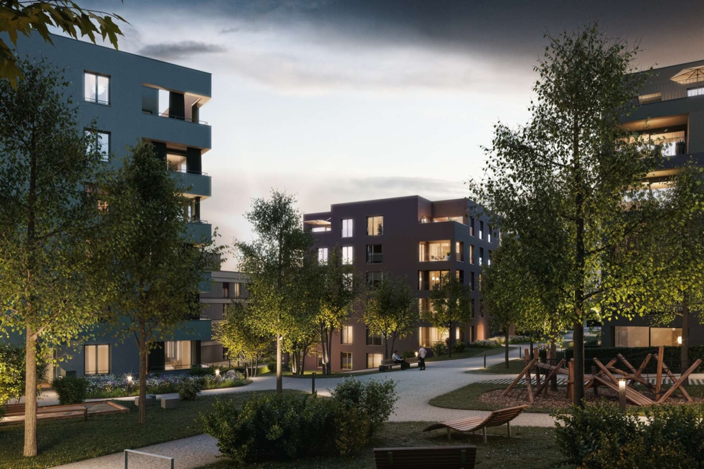 Ein moderner Wohnkomplex in der Abenddämmerung mit beleuchteten Fenstern, begrünten Wegen, Rasenflächen, Bäumen, Bänken und einem Holzspielplatz schafft eine friedliche und einladende Wohnatmosphäre.